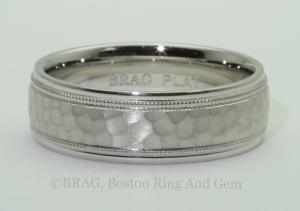 Platinum men's wedding ring with matte hammer center and mill grain edge