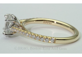 Oval diamond set in a two tone solitaire. 18k yellow gold tapered cathedral band with French cut set diamonds with looped four prong platinum basket