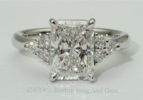 Rectangle radiant cut center diamond with round brilliant cut side stones in a platinum engagement ring