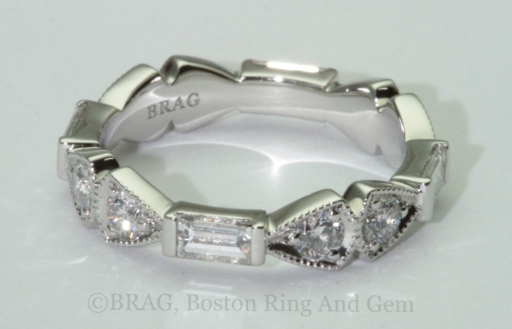 Platinum and diamond eternity wedding ring. Emerald and round brilliant cut diamonds set in triangular and rectangular alternating shapes with mill grain details
